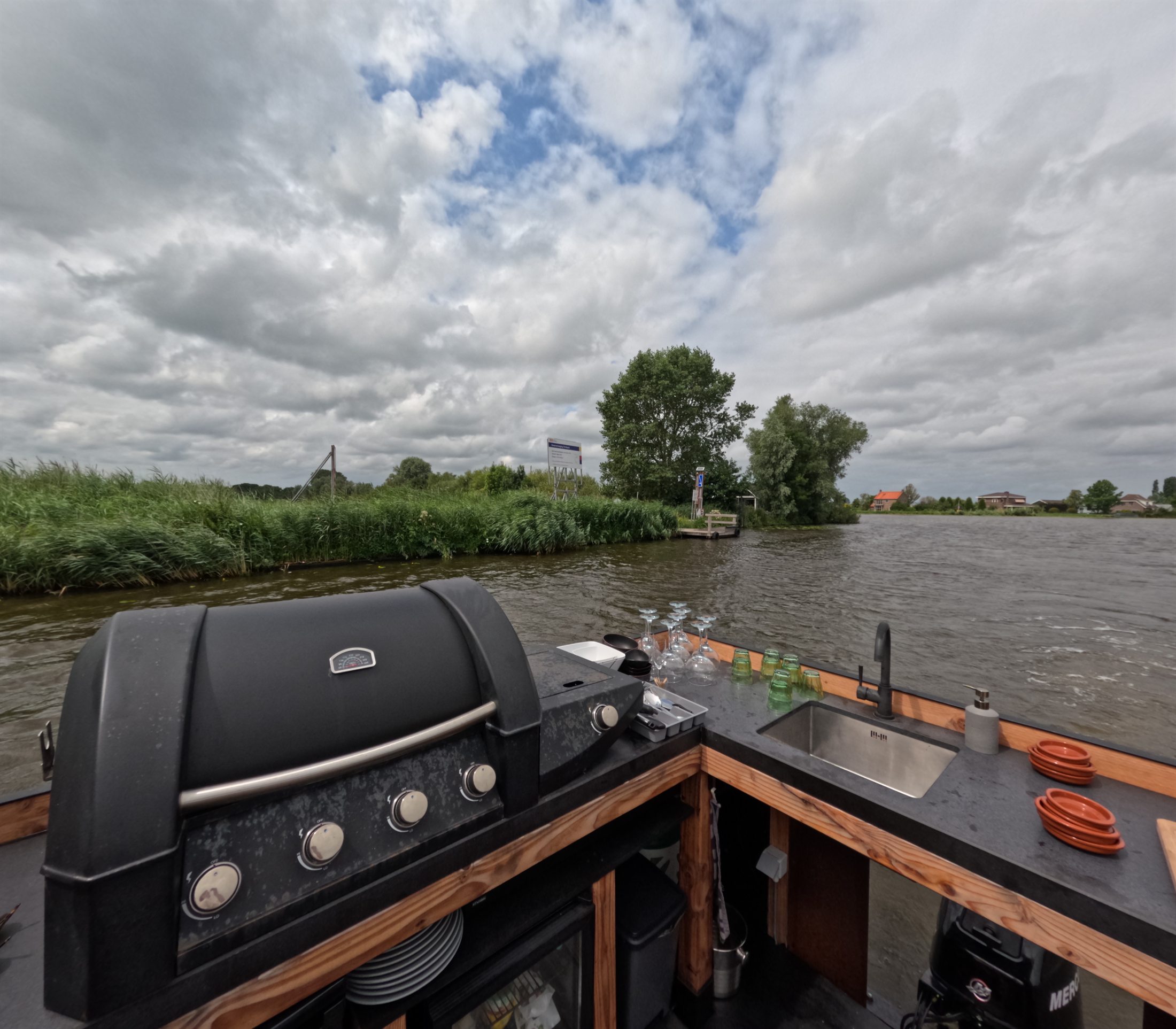 Buitenkeuken met barbecue, spoelbak en glazen aan boord