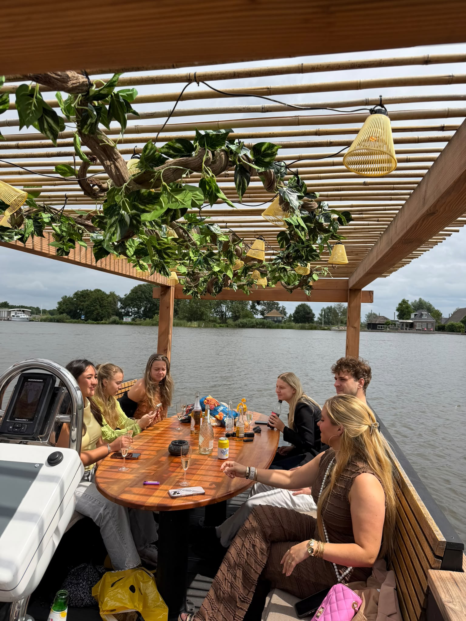 Een vriendengroep rond de lange tafel op de Borrelboot