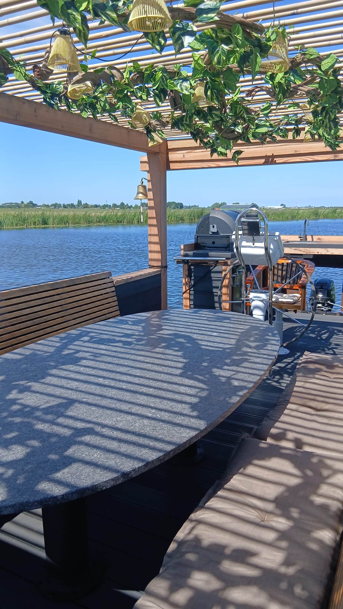 De ruime tafel, zitbanken, stuurstand en barbecue aan boord